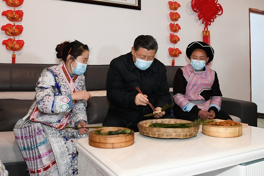 2021年2月3日下午，習(xí)近平在貴州畢節(jié)市黔西縣新仁苗族鄉(xiāng)化屋村苗族村民趙玉學(xué)家，同一家人邊聊家常邊制作當(dāng)?shù)貍鹘y(tǒng)節(jié)日食品黃粑。新華社記者 李學(xué)仁 攝